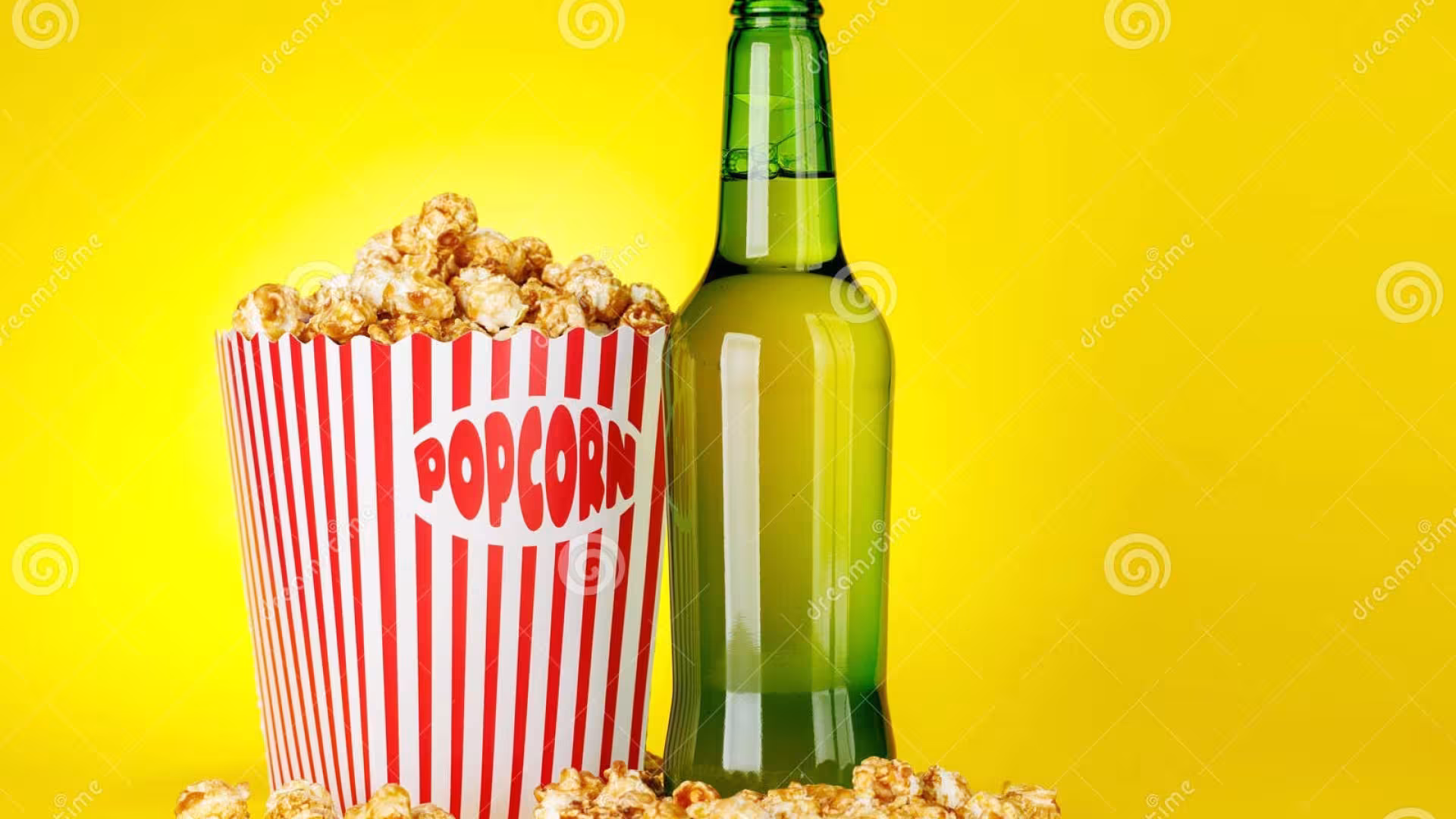Bucket of popcorn and bottle of beer on an amber background
