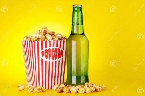 Bucket of popcorn and bottle of beer on an amber background