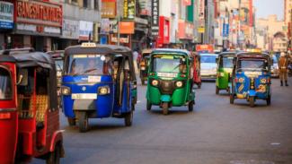 Tuktuks driving down a street in Colombo