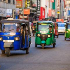 Tuktuks driving down a street in Colombo