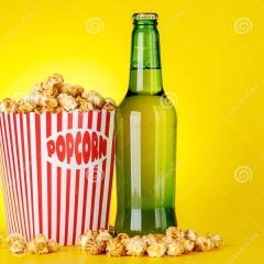 Bucket of popcorn and bottle of beer on an amber background